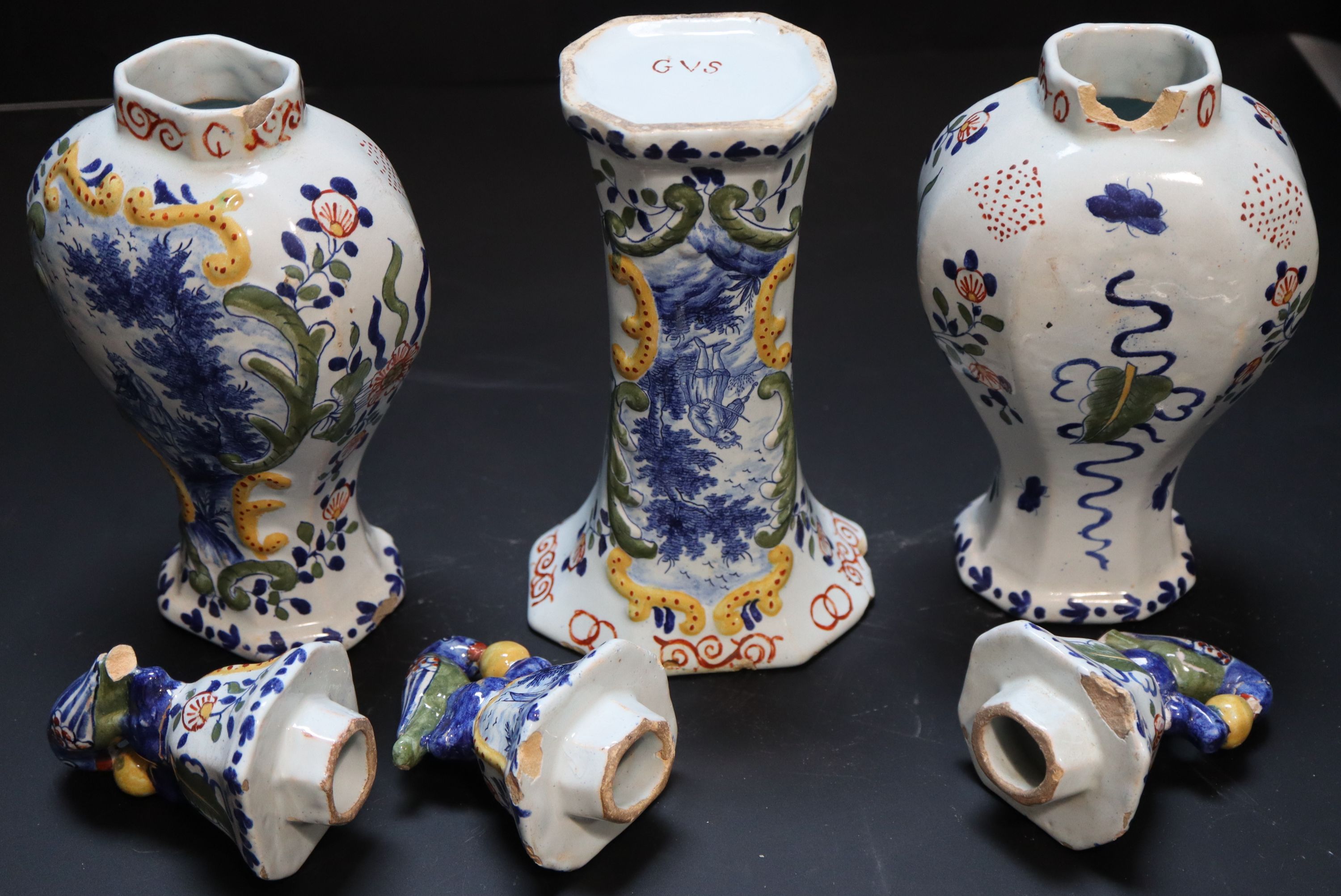 A 19th century Dutch delft polychrome part garniture of three vases, height 27cm and 19cm.